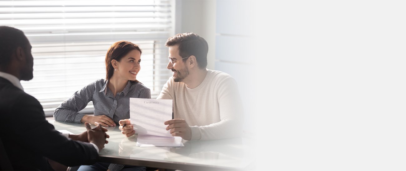 A man and woman are at a table, reviewing a document together